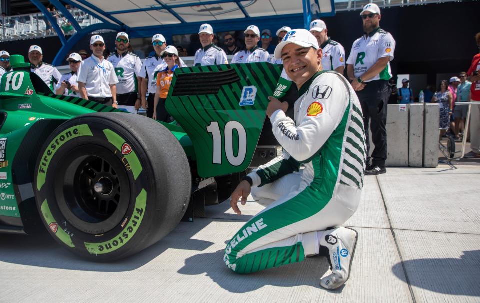 Alex Palou (10) kneels next to his vehicle after winning his second consecutive NTT P1 Award during the NTT IndyCar Series qualifying at the Detroit Grand Prix in downtown Detroit on Saturday, June 3, 2023.