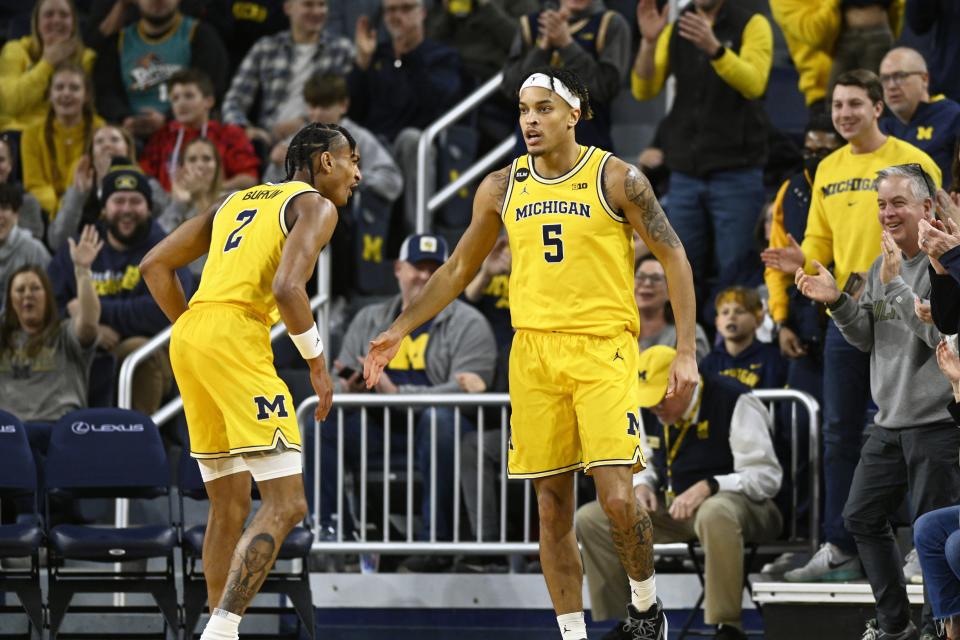 Michigan forward Terrance Williams II, right, is congratulated by Kobe Bufkin after scoring a basket against Maryland in the first half on Sunday, Jan. 1, 2023, at Crisler Center.