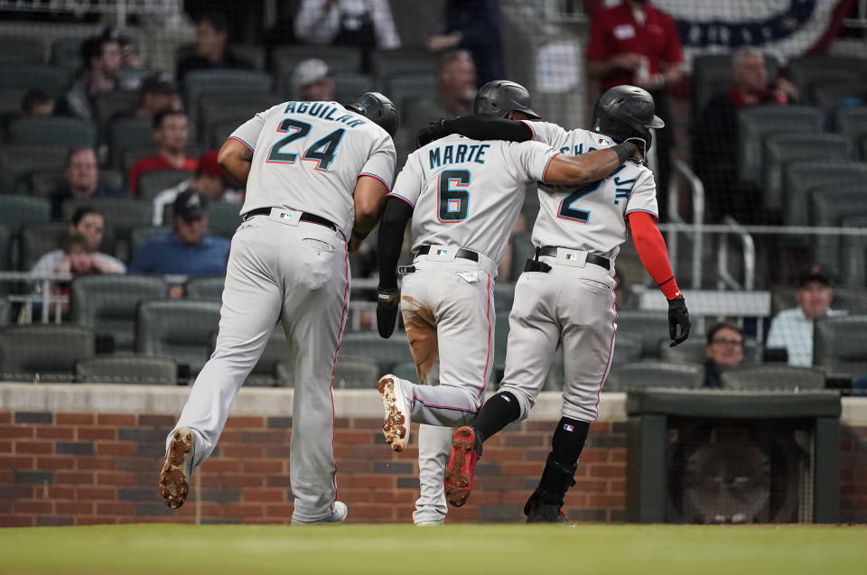 Miami Marlins' Jazz Chisholm Jr. (2) celebrates with Starling Marte (6) and Jesus Aguilar (24) after Chisholm hit a home run during the third inning of the team's baseball game against the Atlanta Braves on Wednesday, April 14, 2021, in Atlanta. (AP Photo/Brynn Anderson)