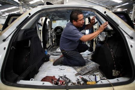 An employee works on a dismantled chasis of a vehicle before armoring it at the garage of Blindajes EPEL company in Mexico City, Mexico April 9, 2018. Picture taken April 9, 2018. REUTERS/Gustavo Graf
