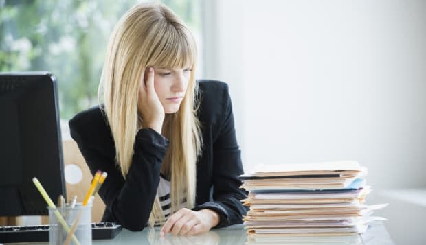 Businesswoman looking at stack of files