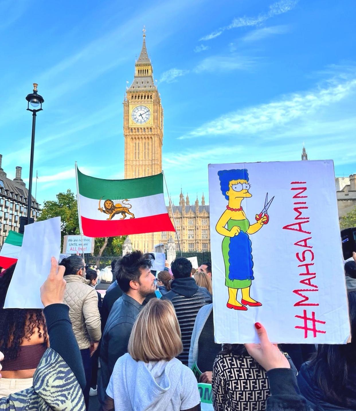 A poster with a drawing of Marge Simpson cutting her hair in support of Iranian women, by aleXsandro Palombo, at a demonstration in London. <a href="https://twitter.com/PalomboArtist/status/1581634741840666624?s=20&t=DH5V4hIgezRW7ELoZsco3A" rel="nofollow noopener" target="_blank" data-ylk="slk:aleXsandro Palombo / TW;elm:context_link;itc:0;sec:content-canvas" class="link ">aleXsandro Palombo / TW</a>