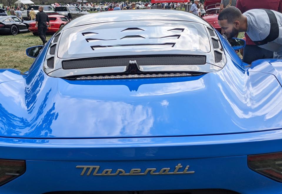 A visitor checks out a Maserati at the Molto Bella Auto Show