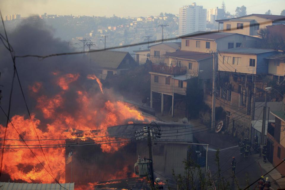 Firefighters try to put out a fire at the location where a forest fire burned several neighbourhoods in the hills in Valparaiso city, northwest of Santiago, April 13, 2014. At least 11 people were killed and 500 houses destroyed over the weekend by the fire that devastated parts of the Chilean port city of Valparaiso, as authorities evacuated thousands and sent in aircraft to battle the blaze. REUTERS/Cristobal Saavedra (CHILE - Tags: SOCIETY ENVIRONMENT DISASTER)