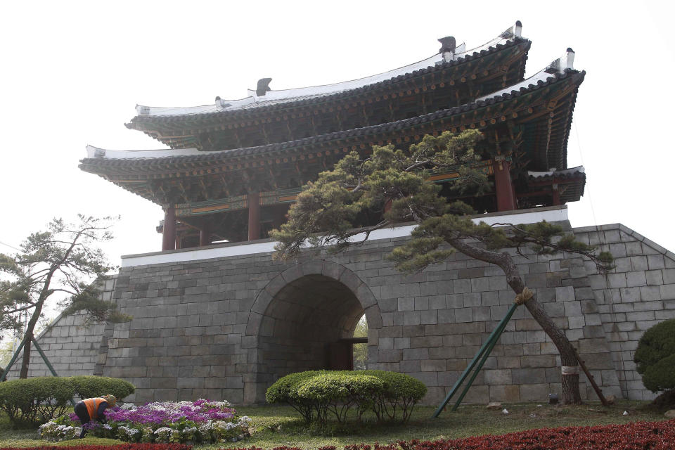 A woman raises flowers at the Pothong Gate in Pyongyang, North Korea Tuesday, April 28, 2020. (AP Photo/Jon Chol Jin)