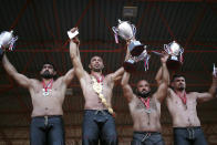 Wrestler Ali Gurbuz, second left, poses for pictures with other top athletes,after winning the final to gain the sport's golden belt in the 660th instalment of the annual Historic Kirkpinar Oil Wrestling championship, in Edirne, northwestern Turkey, Sunday, July 11, 2021.Thousands of Turkish wrestling fans flocked to the country's Greek border province to watch the championship of the sport that dates to the 14th century, after last year's contest was cancelled due to the coronavirus pandemic. The festival, one of the world's oldest wrestling events, was listed as an intangible cultural heritage event by UNESCO in 2010. (AP Photo/Emrah Gurel)