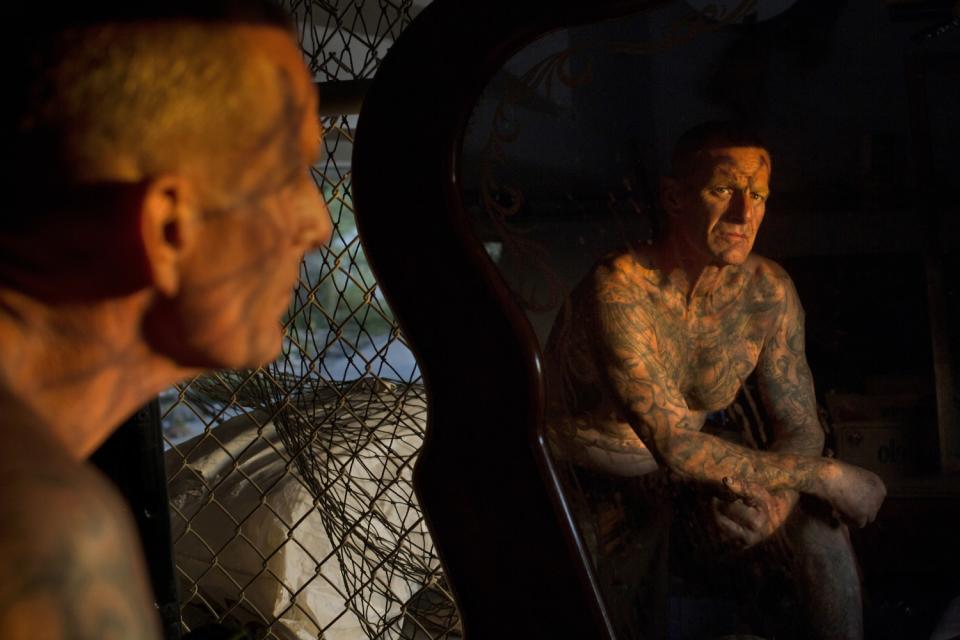 Kenneth Colato looks in the mirror in his home under a bridge along the L.A. River.