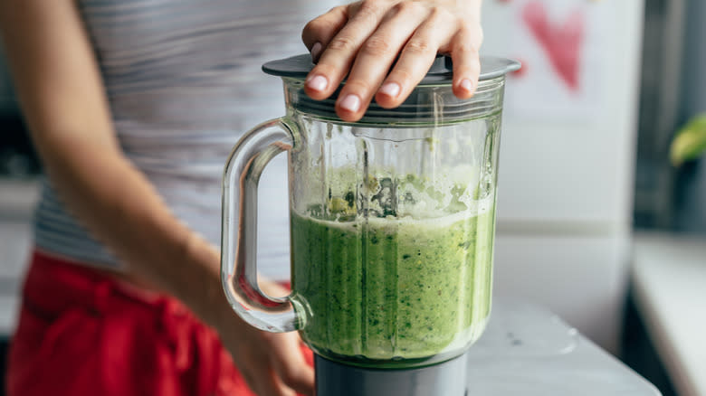 green smoothie being blended in blender