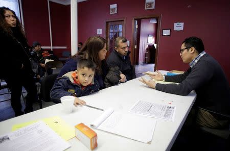 Attorney John Antia (R) talks to migrant family attending a workshop for legal advice held by the Familia Latina Unida and Centro Sin Fronteras at Lincoln United Methodist Church in south Chicago, Illinois, in this January 10, 2016, file photo. REUTERS/Joshua Lott/Files