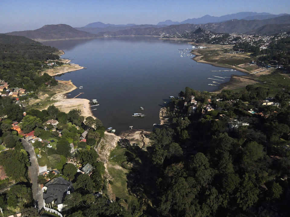 The banks of the Miguel Aleman dam lie exposed due to low water levels in Valle de Bravo, Mexico, Thursday, March 14, 2024. According to Mexico’s National Water Commission, Valle de Bravo’s reservoir has fallen to 29% of its capacity – a historical low -- compared to one year ago when it was at 52%, while the country endures a drought and has imposed restrictions on water taken from the system. (AP Photo/Marco Ugarte)