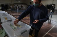 A voter casts his ballot in the Constitutional Convention election to select assembly members that will draft a new constitution, in Santiago, Chile, Saturday, May 15, 2021. The face of a new Chile begins taking shape this weekend as the South American country elects 155 people to draft a constitution to replace one that has governed it since being imposed during a military dictatorship. (AP Photo/Esteban Felix)