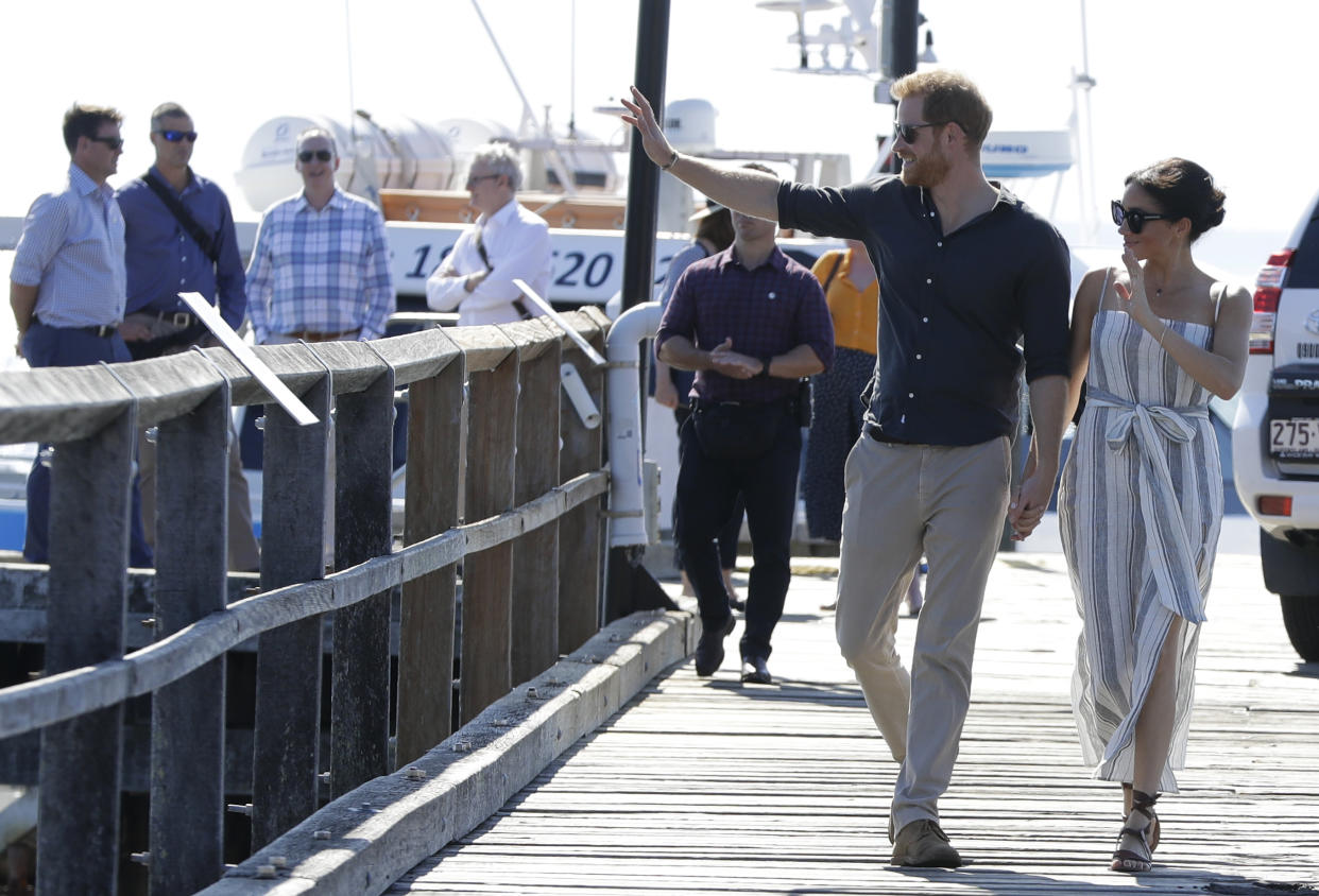 Britain's Prince Harry and Meghan, Duchess of Sussex walk along Kingfisher Bay Jetty during a visit to Fraser Island, Australia, Monday, Oct. 22, 2018. Prince Harry and his wife Meghan are on day seven of their 16-day tour of Australia and the South Pacific. (AP Photo/Kirsty Wigglesworth, Pool)