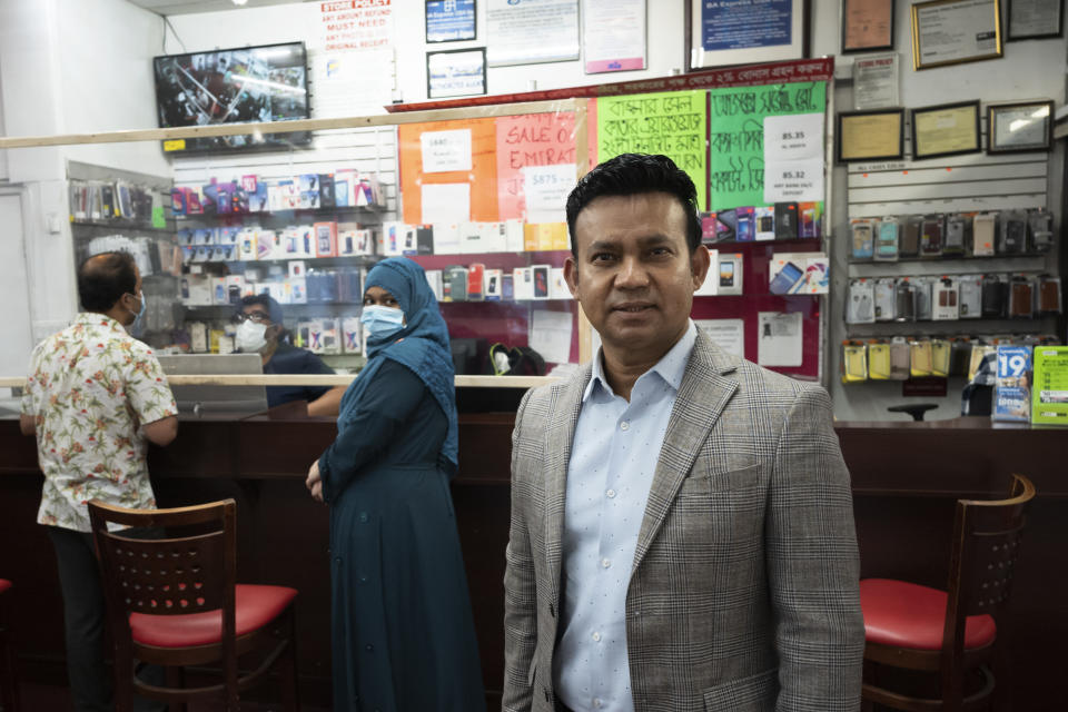 Zakaria Masud stands in his travel agency after it reopened during the coronavirus pandemic, June 18, 2020, in New York's Jackson Heights neighborhood. Masud said, "I was excited after a long time that we were opening the store. At the same time, I had panic, a little scared that people are going to walk in, am I going to get sick?" (AP Photo/Mark Lennihan)
