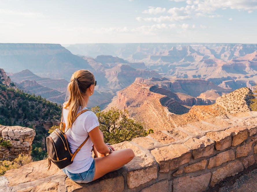 woman sitting on the edge of the grand canyon