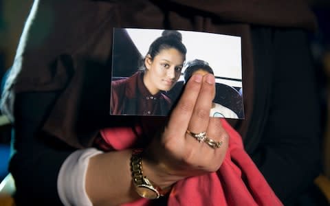 Renu, eldest sister of Shamima Begum, 15, holds her sister's photo while being interviewed by the media at New Scotland Yard, central London - Credit: PA