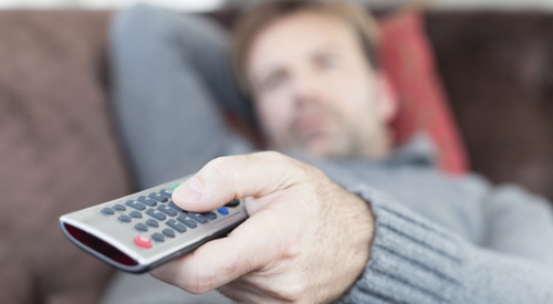 Man lying on couch with remote