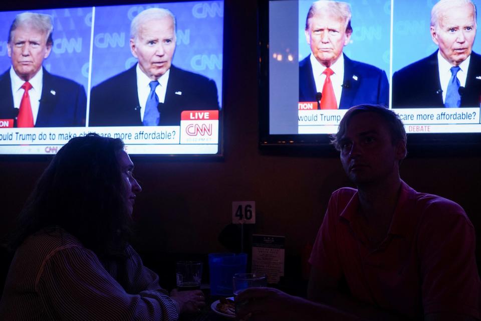 Republican presidential candidate, former U.S. President Donald Trump and Democrat presidential candidate, U.S. President Joe Biden are seen on television as people attend a watch party for the first U.S. presidential debate hosted by CNN in Atlanta, at Union Pub on Capitol Hill in Washington, U.S., June 27, 2024.