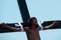 A Filipino Roman Catholic grimaces as he is nailed to a cross during the a re-enactment of the Crucifixion during Good Friday celebrations in the village of Santa Lucia, Pampanga, north of Manila on April 18, 2014