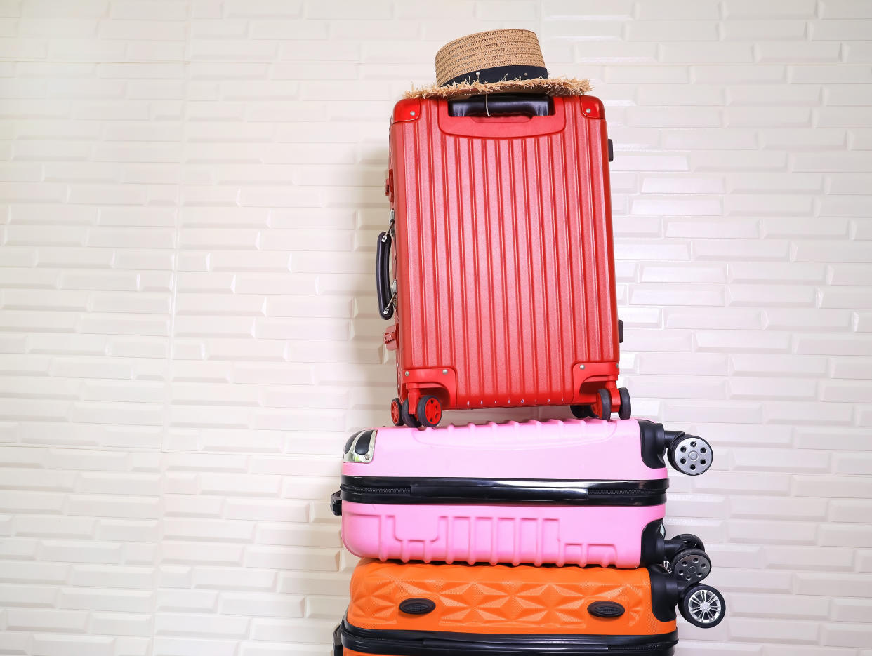 Pile of colors different heavy luggage on white wall background. Overweight concept