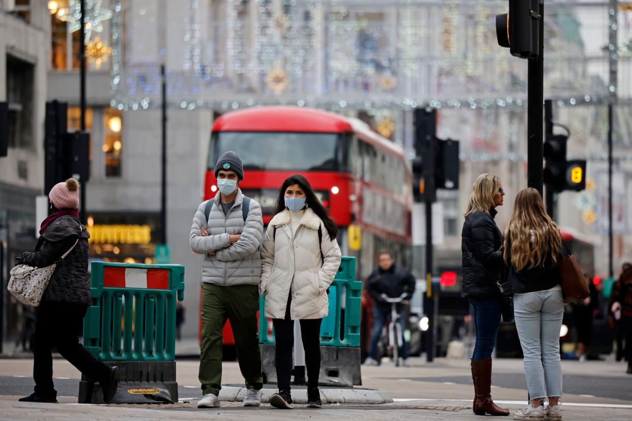 Pedestrians wearing a protective face coverings to combat the spread of the coronavirus, walk down Oxford Street in central London on November 27, 2020, as life under a second lockdown continues in England. - England will return to a regional tiered system when the national stay-at-home order ends on December 2, and 23.3 million residents in the worst-hit areas are set to enter the "very high" alert level. (Photo by Tolga Akmen / AFP) (Photo by TOLGA AKMEN/AFP via Getty Images)