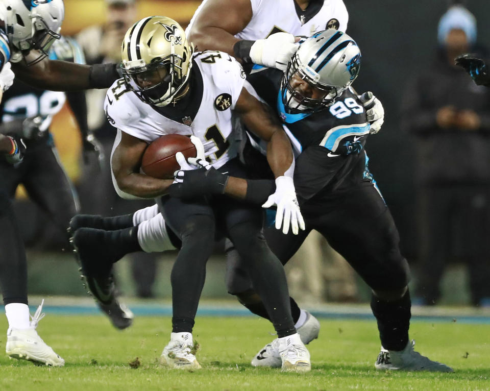 New Orleans Saints' Alvin Kamara (41) is tackled by Carolina Panthers' Kawann Short (99) in the first half of an NFL football game in Charlotte, N.C., Monday, Dec. 17, 2018. (AP Photo/Jason E. Miczek)