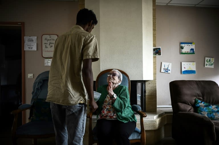 Un jeune migrant offre une morceau de pastèque à une personne âgée dans une résidence intergénérationnelle à Sciecq, dans les Deux-Sèvres, le 30 mai 2024 (Philippe LOPEZ)