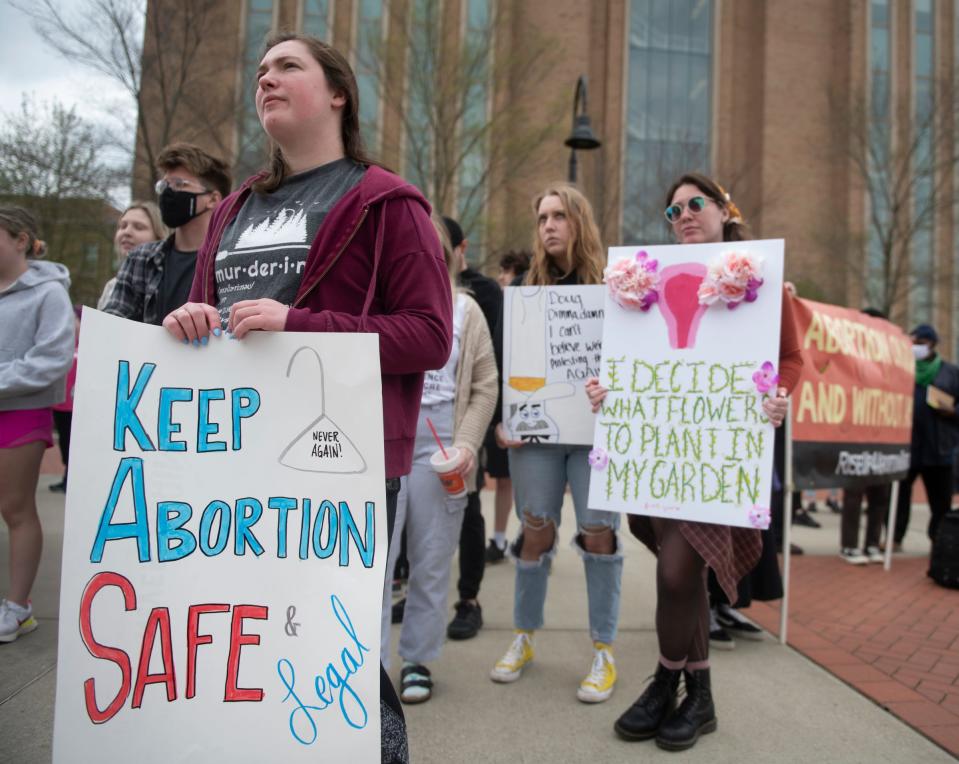 Homemade signs are held by protesters during a really for reproductive rights at Kent State University on Thursday. Students for a Democratic Society organized a protest in support of reproductive rights after a leaked Supreme Court decision to overturn Roe v. Wade. The rally started at Risman Plaza, where the crowd continued to grow, and then marched to the Rock on front campus.