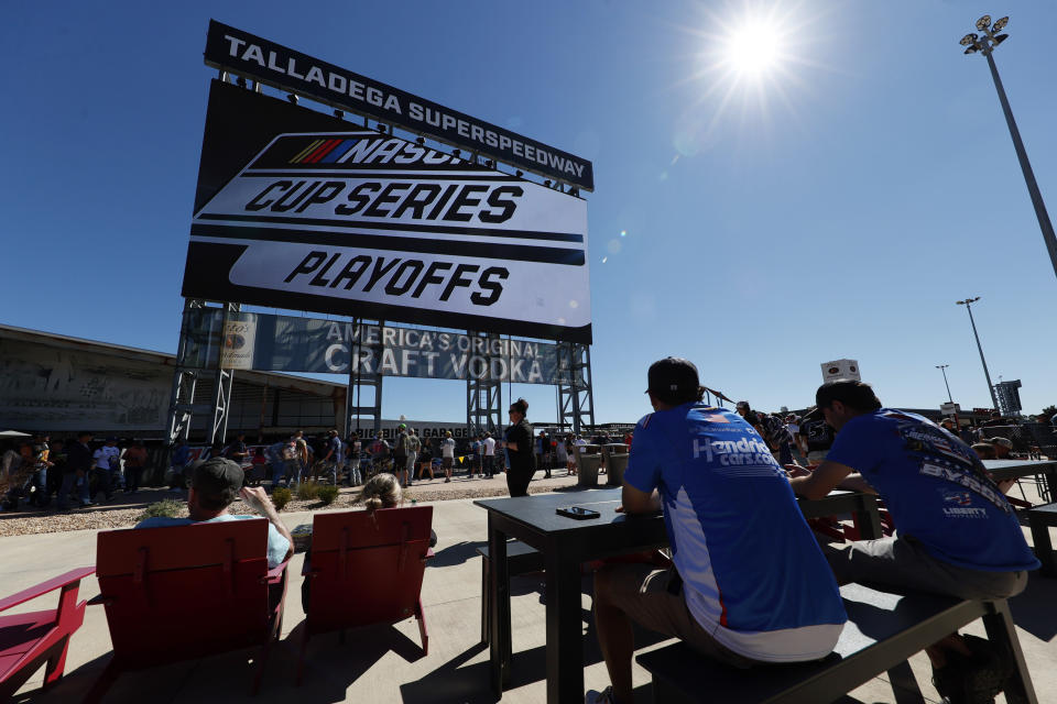 Fans eat and watch the big screen before the NASCAR Cup Series auto race Sunday, Oct. 2, 2022, in Talladega, Ala. (AP Photo/Butch Dill)