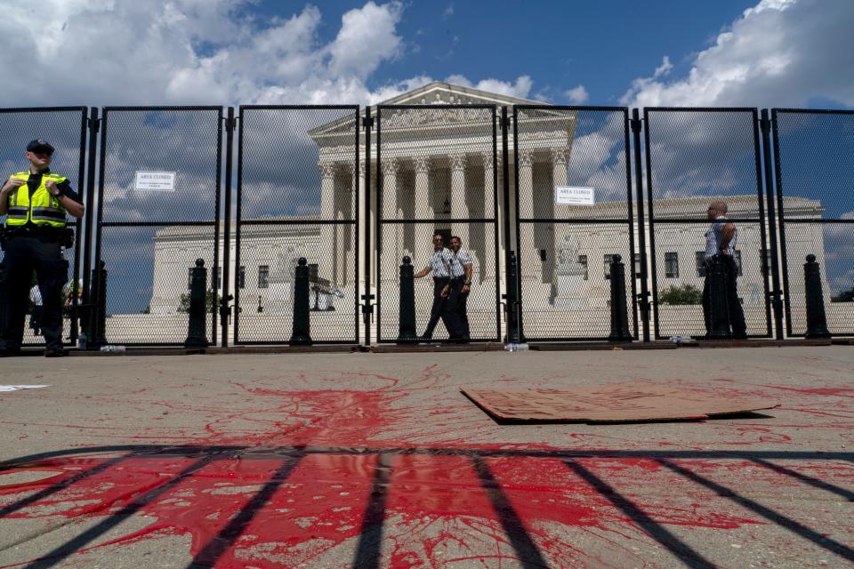 Red painting covers part of the sidewalk outside the Supreme Court as people protest about abortion in Washington, Saturday, June 25, 2022. The Supreme Court has ended constitutional protections for abortion that had been in place nearly 50 years, a decision by its conservative majority to overturn the court's landmark abortion cases.