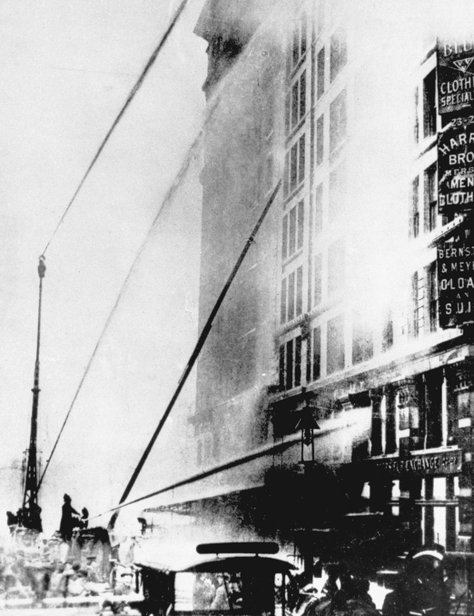 FILE - Firefighters work at the scene of the Triangle Shirtwaist Company fire in the Asch Building on New York's Washington Place, March 25, 1911. The fire killed 146 young girls and women and triggered widespread labor reforms. The victims and legacy of the 1911 Triangle Shirtwaist factory fire are being remembered with a new memorial. A structure of steel is being dedicated Wednesday, Oct. 11, 2023, at the Manhattan building where the tragedy took place. (AP Photo/File)