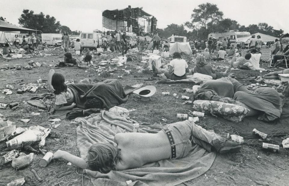 1976: Early morning at the Willie Nelson Fourth of July Picnic outside Gonzales. The photographer said "It is 8:30 and Leon Russell has just been called back for an encore. Many have not awakened yet. Trash is everywhere."