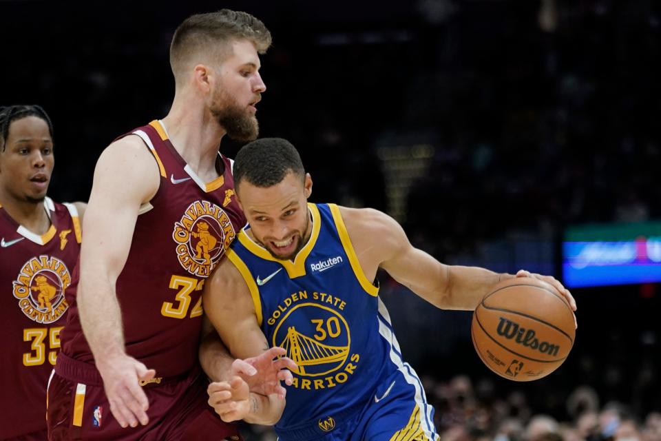 Golden State Warriors guard Stephen Curry (30) drives against Cavaliers forward Dean Wade (32) during the Warriors' 104-89 win Thursday night. Curry scored 20 of his 40 points in the fourth quarter. [Tony Dejak/Associated Press]