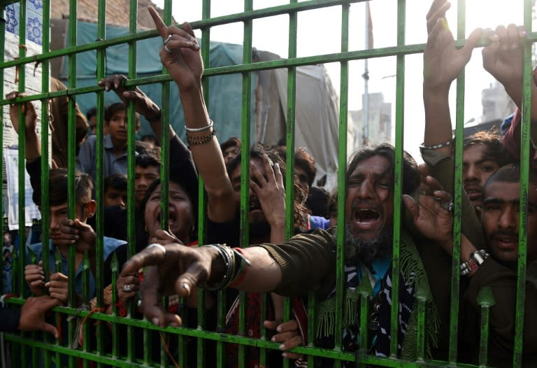 Devotees gather outside the closed gate of the shrine of 13th century Muslim Sufi saint Lal Shahbaz Qalandar, in the souther Pakistani town of Sehwan, on February 17, 2017, a day after a bomb blew up at the shrine