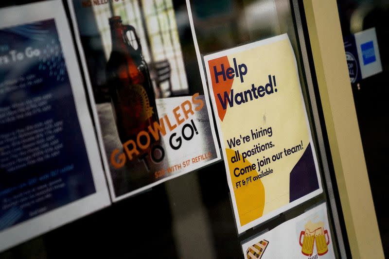 FILE PHOTO: An employee hiring sign is seen in a window of a business in Arlington