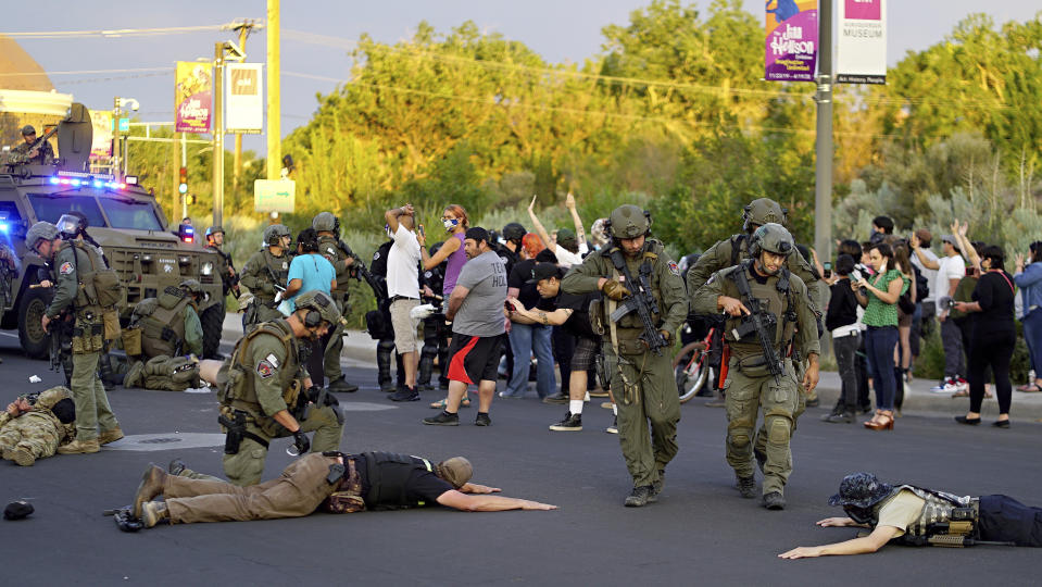 FILE - Albuquerque police detain members of the New Mexico Civil Guard, an armed civilian group, June 15, 2020, in Albuquerque, N.M. A confrontation erupted between protesters and a group of armed men who were trying to protect a statue of Spanish conquerer Juan de Oñate. New Mexico is considering legal changes to rein in unauthorized paramilitary patrols that intimidate or pose a danger. The bill emerged Monday, March, 6, 2023, from House committee vetting for a possible floor vote amid opposition from Republican legislators. (Adolphe Pierre-Louis/The Albuquerque Journal via AP, File)