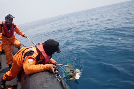 A rescue team member finds debris, possibly from a passenger of Lion Air flight JT610, at the north coast off Karawang, Indonesia, October 31, 2018. Antara Foto/Galih Pradipta via REUTERS