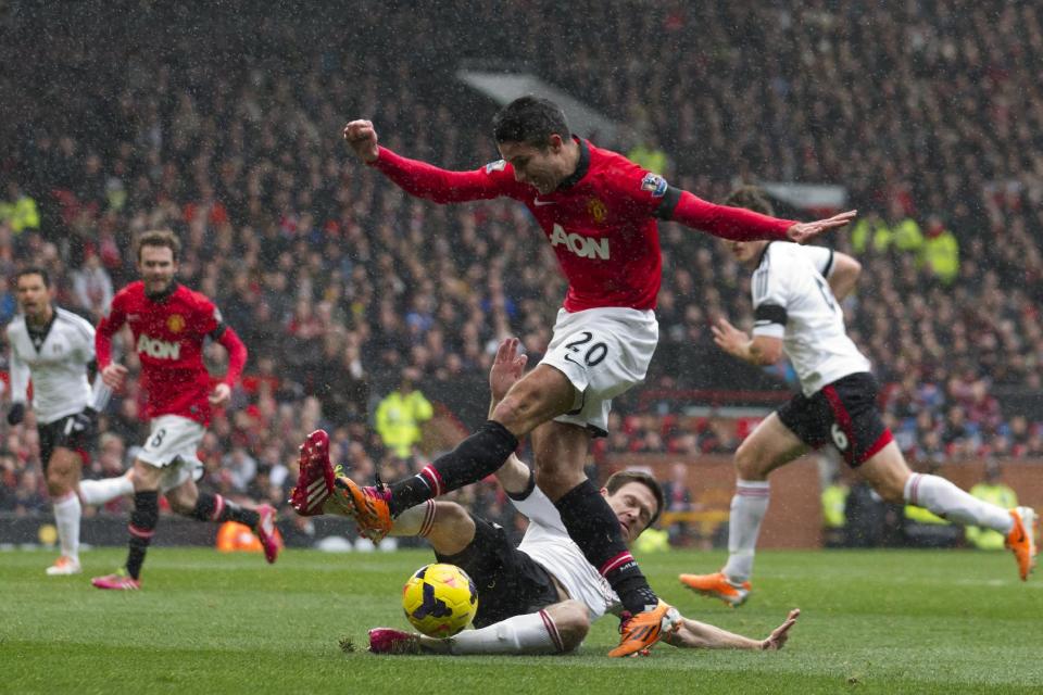 Manchester United's Robin van Persie, top center, is thwarted by Fulham's Sascha Riether during their English Premier League soccer match at Old Trafford Stadium, Manchester, England, Sunday Feb. 9, 2014. (AP Photo/Jon Super)