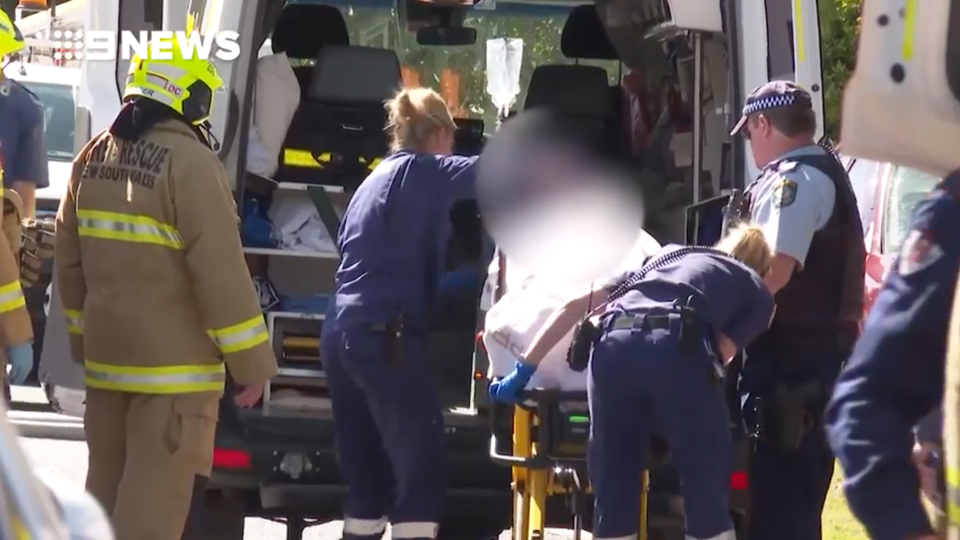 Police and paramedics push a girl, 16, on a stretcher in North Albury.