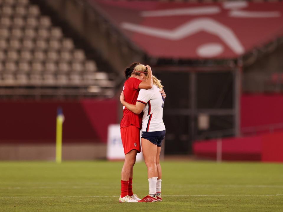 Canada's Christine Sinclair hugs Lindsey Horan of the US Women's National Team.