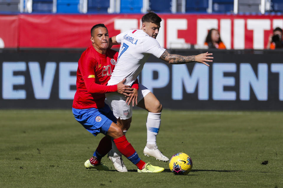 Costa Rica midfielder David Guzman (20) grabs United States forward Paul Arriola (7) during the first half of an international friendly soccer match in Carson, Calif., Saturday, Feb. 1, 2020. (AP Photo/Ringo H.W. Chiu)