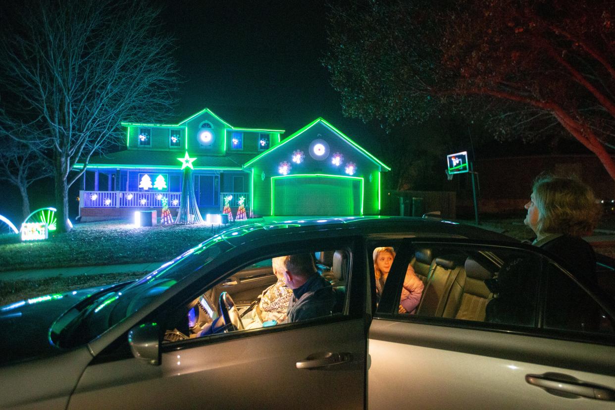 A growing number of Topeka businesses are offering Christmas light display services, which include designing, hanging, removing and storing lights. Here, the Wells family from Meriden stops in front of 4300 S.E Michigan Ave. in Topeka to enjoy the Evans family's display last year.
