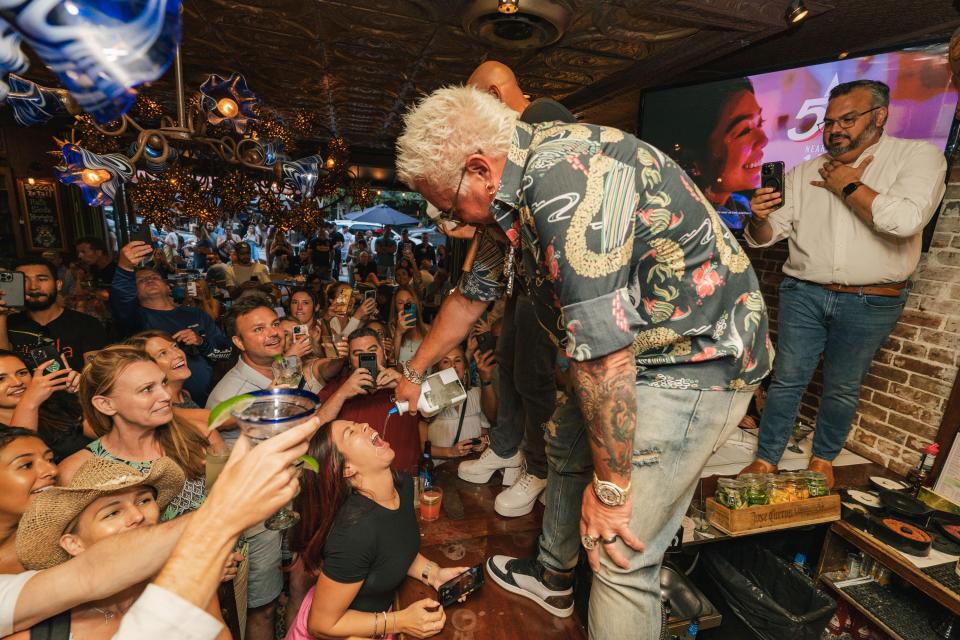 Guy Fieri delivers shots of Santos Tequila to patrons at the Palm Beach International Boat Show after party at Rocco's Tacos on Saturday, March 25.