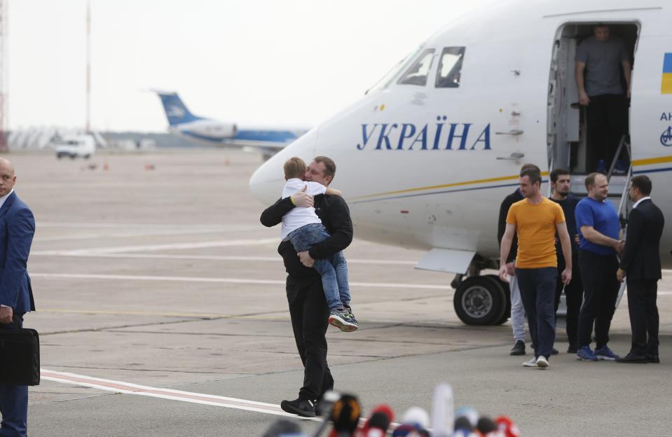 Ukraine's President Volodymyr Zelenskiy, right, greets Ukrainian prisoners upon their arrival at Boryspil airport, outside Kyiv, Ukraine, Saturday, Sept. 7, 2019. Planes carrying prisoners freed by Russia and Ukraine have landed in the countries' capitals, in an exchange that could be a significant step toward improving relations between Moscow and Kyiv. The planes, each reportedly carrying 35 prisoners, landed almost simultaneously at Vnukovo airport in Moscow and at Kyiv's Boryspil airport. (AP Photo/Efrem Lukatsky)