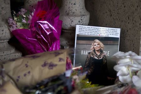 Flowers and a photo, which were left in tribute as part of a makeshift memorial, sit on the steps in front of Joan Rivers' former residence in the Manhattan borough of New York September 6, 2014. REUTERS/Carlo Allegri