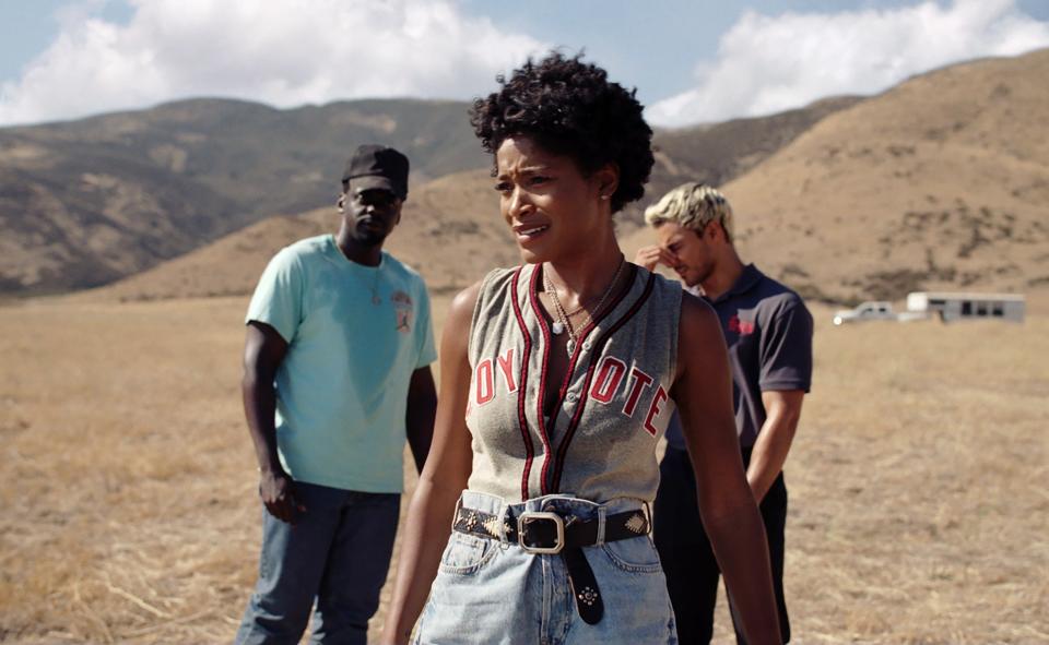 Two men and a woman stand in the middle of a desert