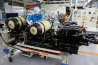 An employee of Toyota Motor Corp. works next to the unit of fuel cell stack and hydrogen tanks of a Mirai fuel cell vehicle (FCV) on it's assembly line at the company's Motomachi plant in Toyota, Aichi prefecture, Japan, May 17, 2018. Picture taken May 17, 2018. REUTERS/Issei Kato