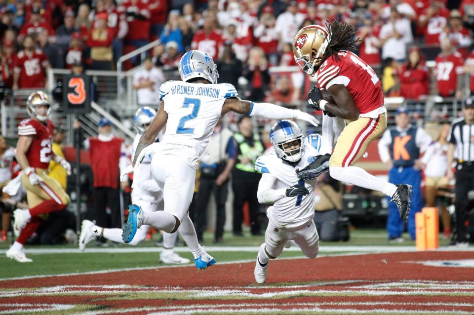 49ers wide receiver Brandon Aiyuk catches the ball around Lions defensive backs C.J. Gardner-Johnson, left, and Cam Sutton for a touchdown in the third quarter of the Lions' 34-31 loss in the NFC championship game in Santa Clara, California, on Jan. 28, 2024.