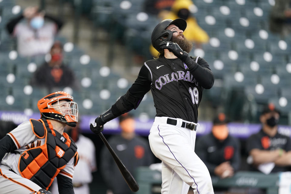 Colorado Rockies' Charlie Blackmon, right, pops out as San Francisco Giants catcher Buster Posey looks on in the seventh inning of game one of a baseball doubleheader Tuesday, May 4, 2021, in Denver. The Giants won the opening game of the twinbill by a score of 12-4. (AP Photo/David Zalubowski)