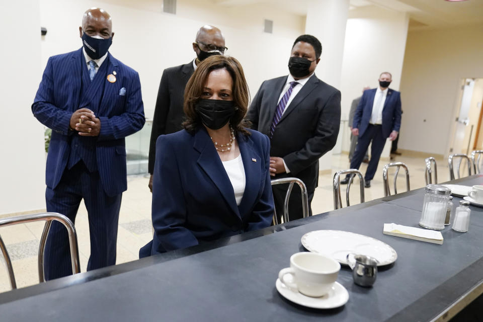 Vice President Kamala Harris sits at the lunch counter where four Black students sat down at Woolworth's lunch counter in Greensboro, N.C., and ordered coffee, during her visit to the International Civil Rights Center and Museum, Monday, April 19, 2021, in Greensboro, N.C. With Harris are Melvin Skip Alston-Guilford, County Board of Commissioners, Rev. Anthony Spearman and museum director John Swain. Harris is sitting in the same chair that Rosa Parks sat in during a visit in 1995. (AP Photo/Carolyn Kaster)