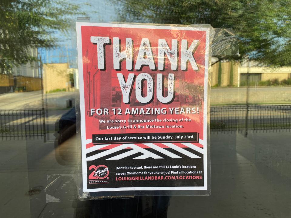 A sign hangs on the window of the former Louie's Grill and Bar in Midtown announcing its closure.